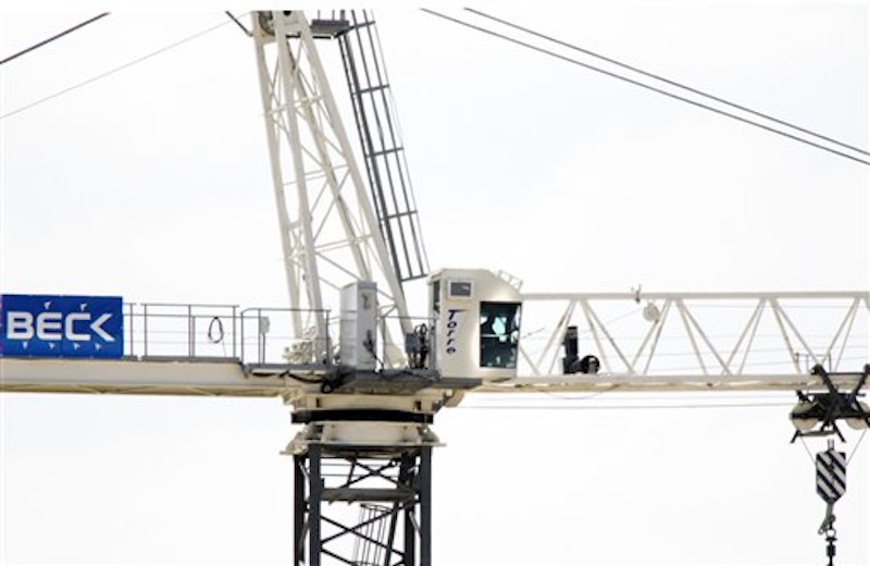 A man sits in a crane 150 feet above the Southern Methodist University campus in Dallas, threatening to shoot the Dallas Police officers trying to talk him down, Monday, May 28, 2012. Special tactics officers from the Dallas Police Department were working with SMU campus police to manage the scene and try to talk the man down from the crane. Early Tuesday, the man fell to his death. (AP Photo/The Dallas Morning News, David Woo)