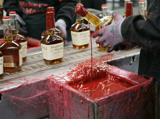 A bottle of Maker's Mark bourbon is dipped in red wax during a tour of the distillery in Loretto, Ky., recently.