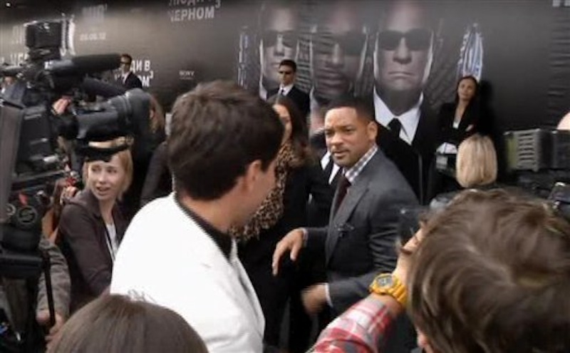 In this video image taken from AP video U.S. actor Will Smith, center right, walks away from reporter Vitalii Sediuk, white suit, from the Ukrainian television channel 1+1 after slapping him on the red carpet before the premiere of "Men in Black III" Friday May 18, 2012 in Moscow. Hollywood star Will Smith has slapped a male television reporter who tried to kiss him before the Moscow premiere of "Men in Black III." Smith pushed him away and then slapped him lightly across the cheek with the back of his left hand. (AP Photo via AP video)