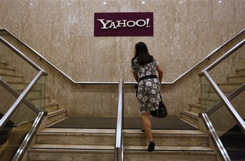 A woman walks up stairs in front of the logo of Yahoo in its Hong Kong office in Hong Kong Monday, May 21, 2012. Struggling Internet company Yahoo Inc. has secured a lifeline after agreeing to sell half of its prized stake in Chinese e-commerce group Alibaba for about $7.1 billion, with most of the cash going to shareholders. (AP Photo/Vincent Yu)
