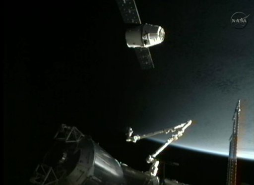 This image provided by NASA-TV shows the SpaceX Dragon commercial cargo craft, top, as Dragon approaches the International Space Station, Friday, May 25, 2012. Dragon is scheduled to spend about a week docked with the station before returning to Earth on May 31 for retrieval. (AP Photo/NASA)