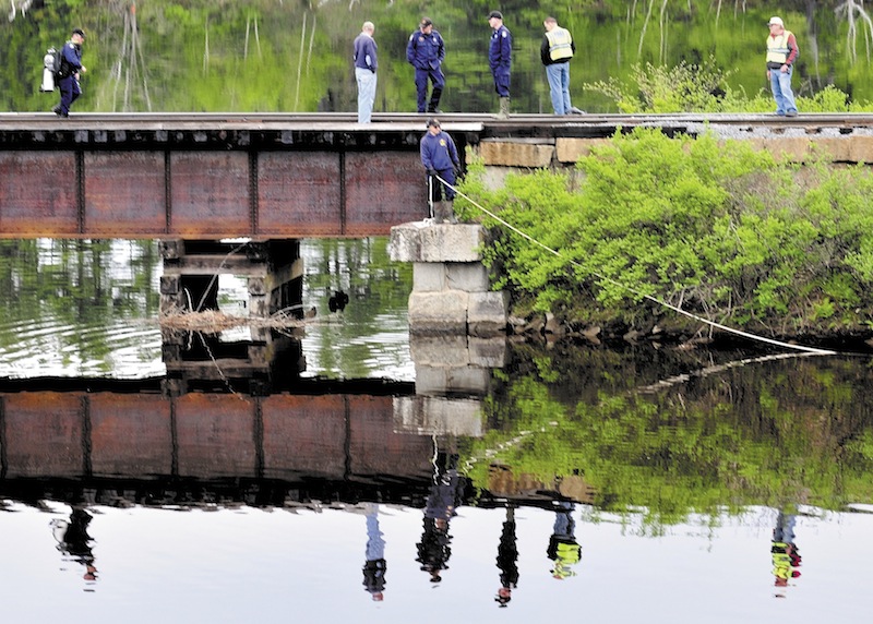Maine State Police divers search Martin Stream near the Kennebec River off U.S. Route 201 in Hinckley on Sunday for the body of a woman driver after her vehicle left the road late Saturday evening.