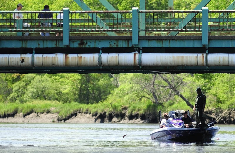 People on the Route 24 bridge watch as one of the search boats returns to Philip Mailly Waterfront Park in Bowdoinham as the search for Santana Dubon, 32, of Portland continues this morning.