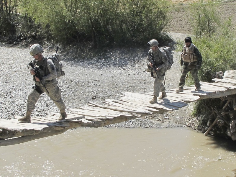 Soldiers from Bravo Company’s 1st Platoon and a member of the Afghan Border Police cross a bridge near Meydani, Afghanistan, in 2010.