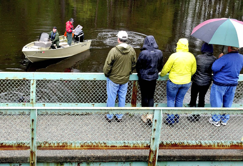 WAIT AND WATCH: Family members of missing driver Cora Marley watch as game wardens in a boat and divers search Martin Stream in Hinckley on Tuesday at the site where Marley's vehicle struck a bridge and sank last Saturday.