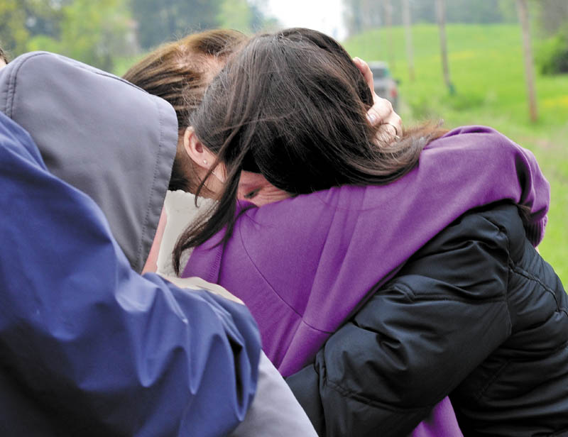 COMFORT: Paula Berry, right, daughter of missing driver Cora Marley, hugs Marley's twin sister Dora Gagnon in Hinckley on Tuesday where an extensive search is underway for Marley who crashed into a bridge over Martin Stream last Saturday.