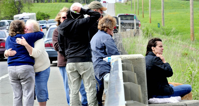 PAINFUL WAIT: Missing driver Cora Marley's daughter Paula Berry, right, watches divers search for her mother with other family members on the bridge over Martin Stream in Hinckley on Tuesday. Marley's sister Earlene Morin, second from left, hugs friend Cindy Johnson.