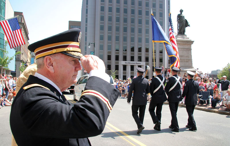 Col. Arthur Wickham of Windham, U.S. army retired, salutes as the Portland color guard passes by along Congress Street during the Portland Memorial Day parade today.