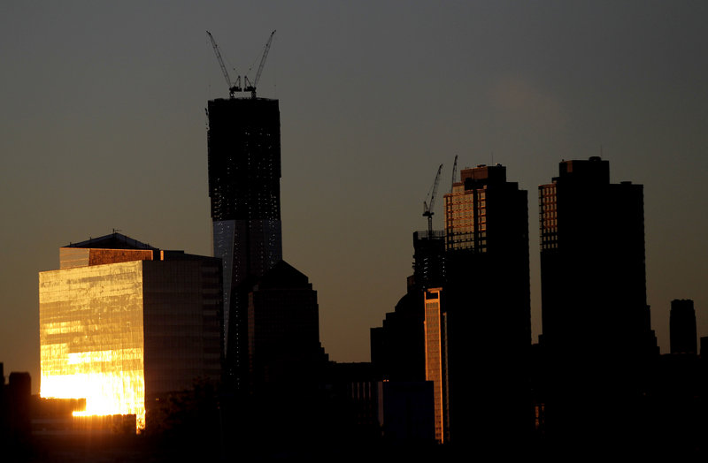 The sun reflects off buildings Monday, including One World Trade Center, center left, in New York. One World Trade Center replaces the twin towers destroyed on Sept. 11, 2001.