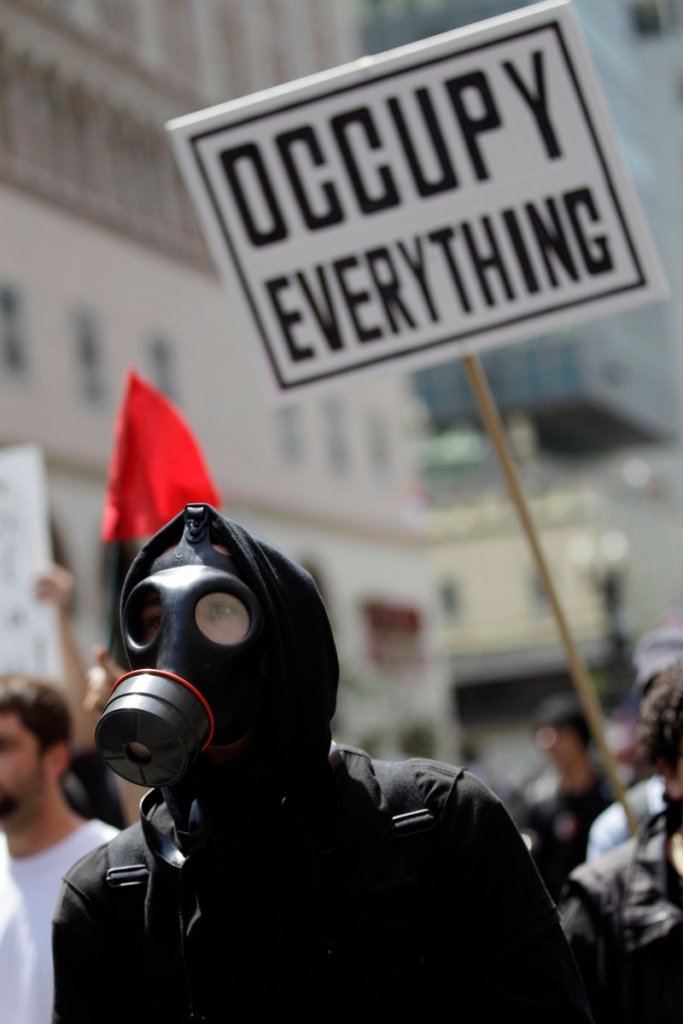 A demonstrator in Oakland, Calif., marches wearing a gas mask Tuesday, as hundreds of activists across the U.S. joined the worldwide May Day protests.