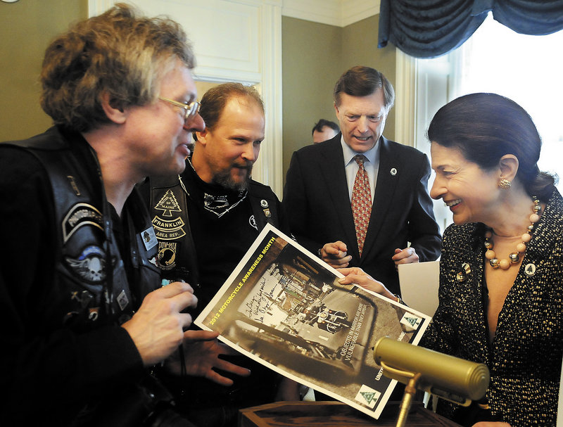 Sen. Olympia Snowe and her husband, former Gov. John McKernan, second from right, sign posters during the United Bikers of Maine annual tea at the Blaine House in Augusta.