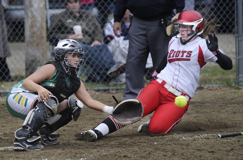 Sam DiBiase of South Portland slides safely into home as Massabesic catcher Amber Libby waits for the throw during South Portland's 17-0 softball victory Wednesday.