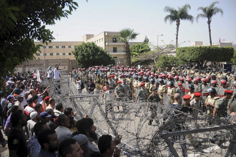 Protesters and security forces face off across a barbed wire barricade in Cairo Wednesday. After Wednesday’s clashes, the military warned Thursday that deadly force was still an option.