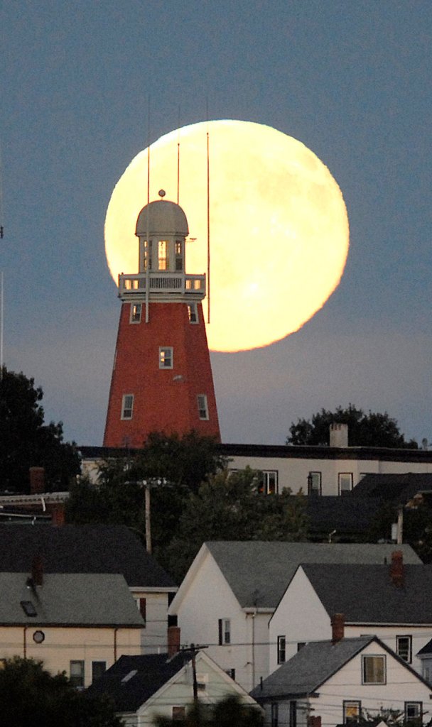 A view of a full moon from across Back Cove several years ago accents the Portland Observatory on Portland’s Munjoy Hill. Despite many beliefs, the full moon doesn’t cause unusual events, a psychologist says.