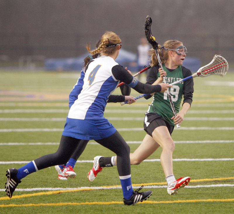 Martha Veroneau of Waynflete carries the ball toward the goal while being chased by two Falmouth players, including Ashleigh Burton, front. Veroneau finished with four goals and two assists, helping the Flyers to a 13-10 victory.