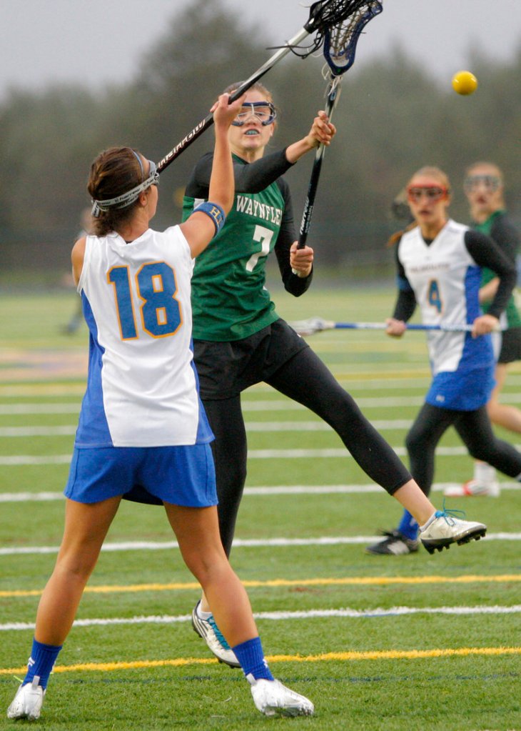 Walker Foehl of Waynflete fires a shot for one of her four goals Friday against Falmouth despite the defense of Vanessa Audet. Waynflete improved to 6-0 and handed Falmouth its first loss, 13-10.