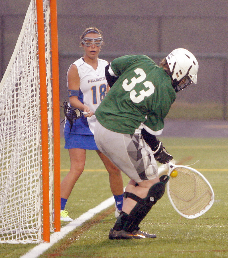 Waynflete goalie Katherine Torrey blocks a shot as Falmouth’s Vanessa Audet looks on. Torrey finished with 11 saves against a Falmouth team that was averaging more than 15 goals per game.