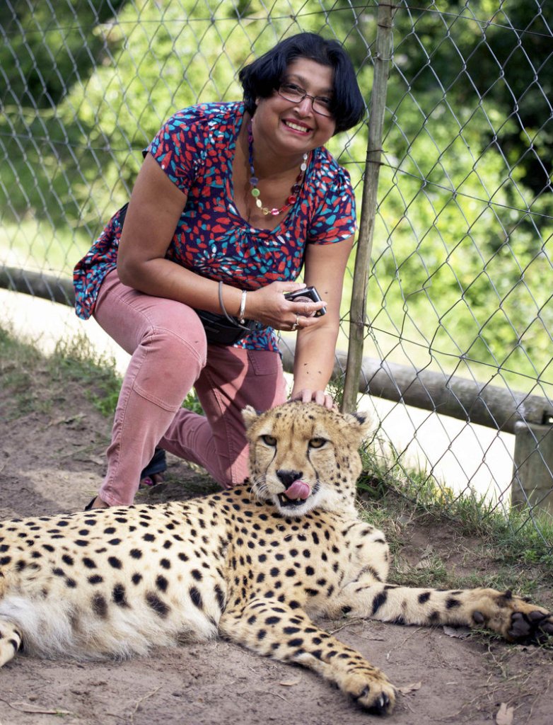 Violet D’Mello of Aberdeen, Scotland, smiles in a petting enclosure with a human-raised cheetah, left, shortly before she was attacked by the two cheetahs.