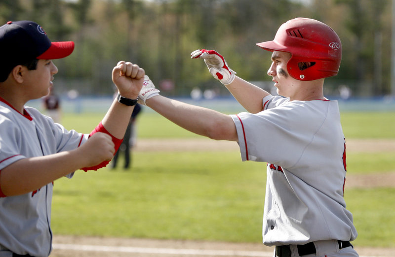 Justin McKenna of Gray-New Gloucester is congratulated Saturday after scoring the first run of the game in the third inning of a 5-0 victory against Freeport that sent the Falcons to their first loss. Gray-New Gloucester is 4-3.