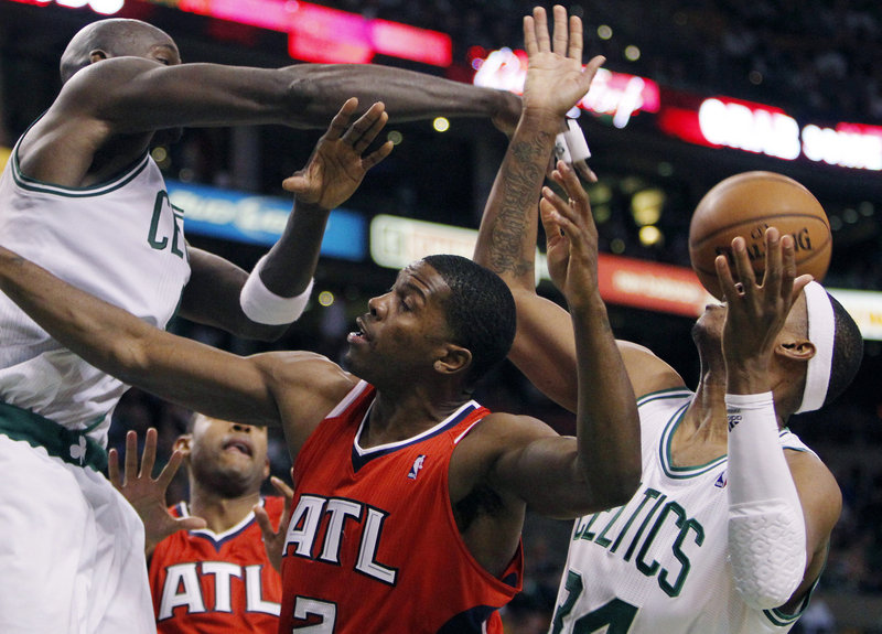 Atlanta’s Joe Johnson, center, loses control of the ball between Boston’s Kevin Garnett and Paul Pierce during Game 4 of their Eastern Conference first-round series Sunday night. The Celtics led by as many as 37 points on the way to a 101-79 win.