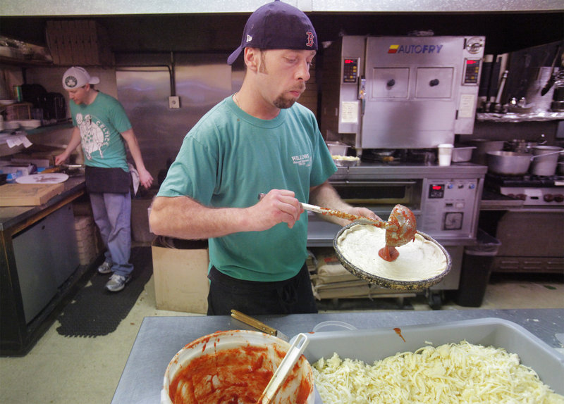 James Fowler begins to top a round of dough at Willows Pizza and Restaurant in South Portland.