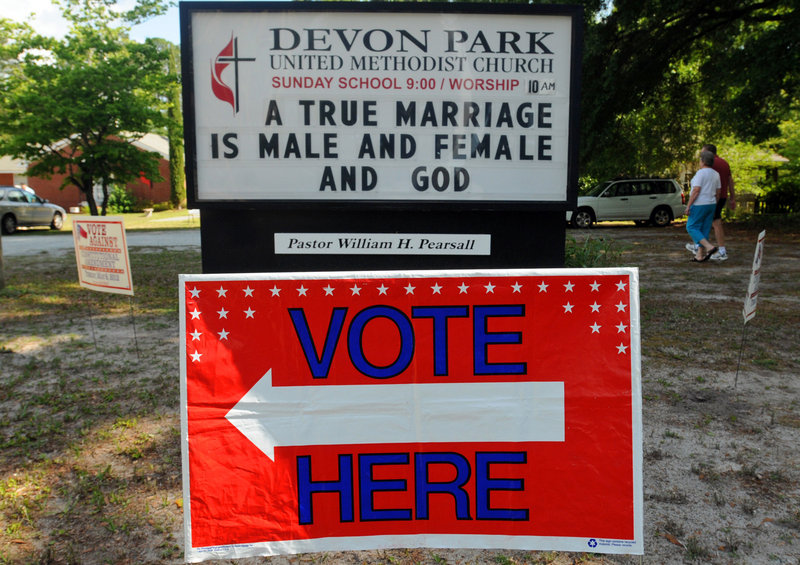 The messages on signs were all about religion and politics Tuesday in front of the Devon Park United Methodist Church election site in Wilmington, N.C., as voters went to the polls.