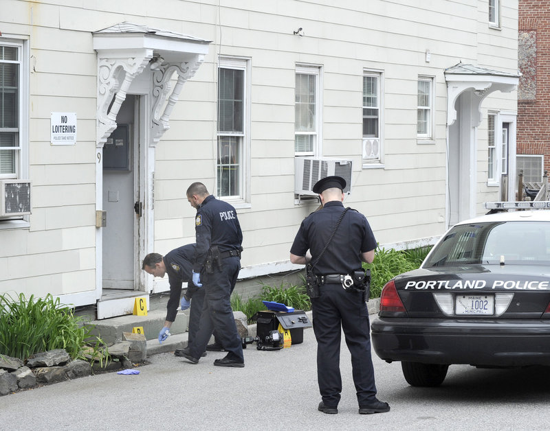 Portland police officers investigate the scene of a stabbing Wednesday outside 9 Cedar St. in Portland.