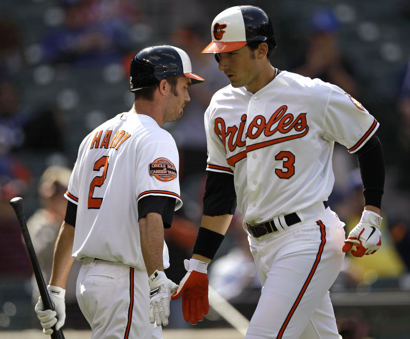 Ryan Flaherty, right, of the Orioles is congratulated J.J. Hardy after hitting a solo homer in the first inning of the opener of their doubleheader against the Rangers on Thursday. Flaherty, a former Deering High standout, went a combined 2 for 5 in the games.