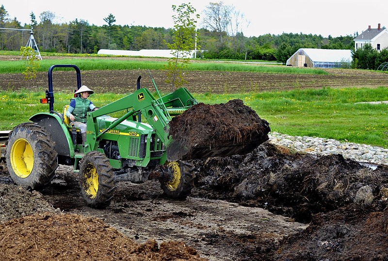 Maggie Akstin, a farmworker with Broadturn Farm, turns over compost using a front-end loader. The farm is permanently protected by an agricultural conservation easement held by Maine’s Department of Agriculture, Food and Rural Resources.