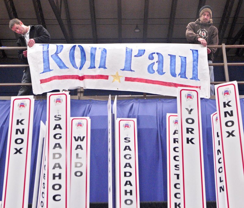 Toby Hoxie of Hallowell, left, and Chad Libby of Winthrop hang up a banner for Ron Paul last week prior to the Maine GOP convention, which his backers dominated.