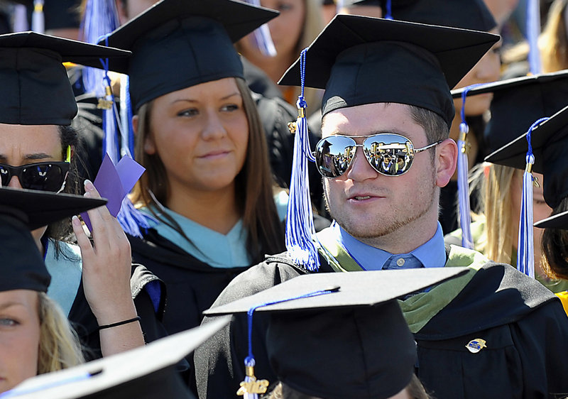 Other graduates are reflected in the glasses of one graduate as they march into the Saint Joseph’s College commencement.