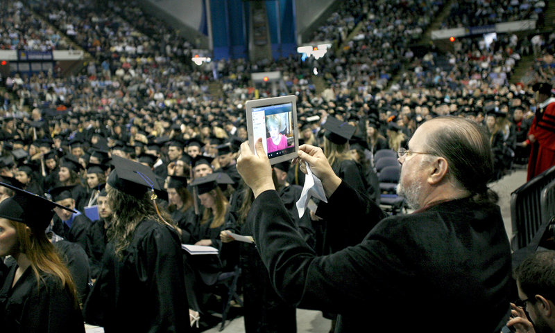 Jack Smith of Sanford holds up an iPad to Skype the graduation ceremonies to his daughter-in-law’s parents living in Belarus during the USM commencement Saturday. Anastasiya Smith received her degree in psychology.