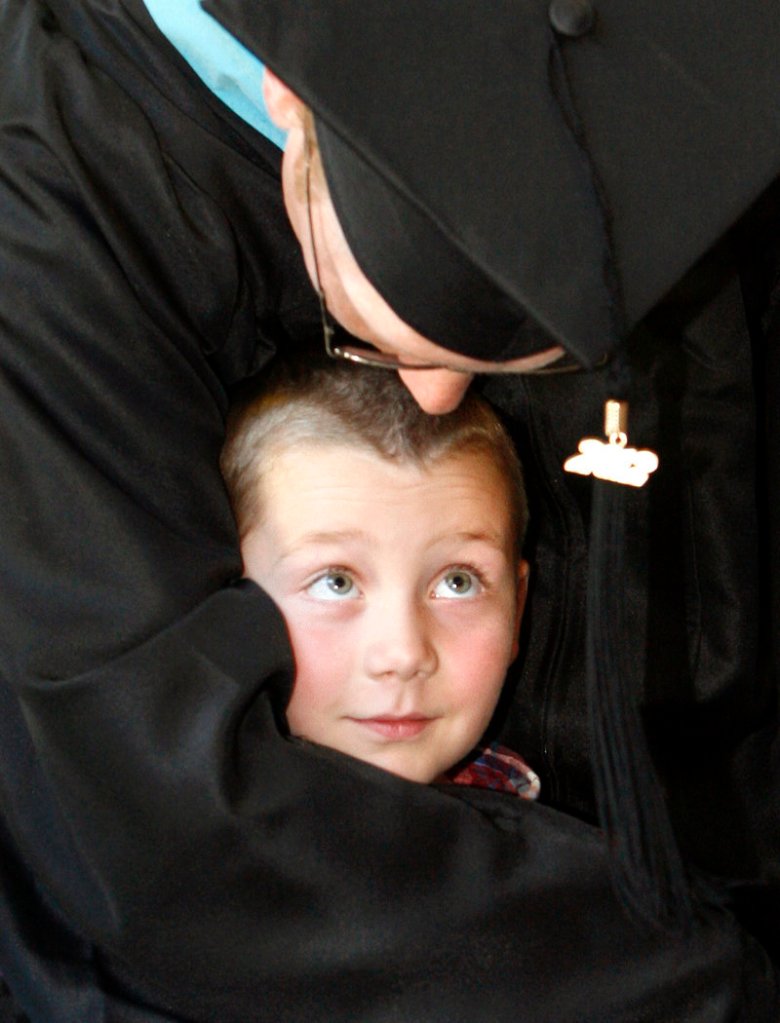 Seth Vincent of Auburn wraps his arms around his son Brady, 6, after receiving his master’s degree in educational psychology during the USM commencement Saturday.