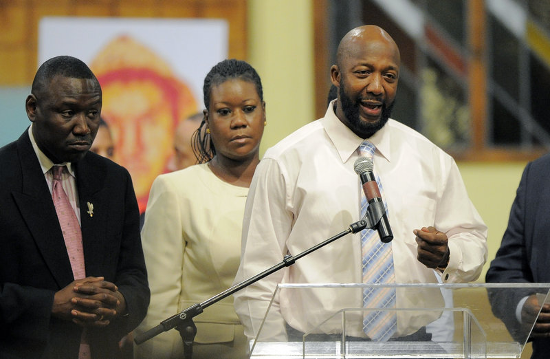 Tracy Martin, right, speaks as Sybrina Fulton, center, and attorney Benjamin Crump look on during a rally on behalf of the family of shooting victim Trayvon Martin in April.