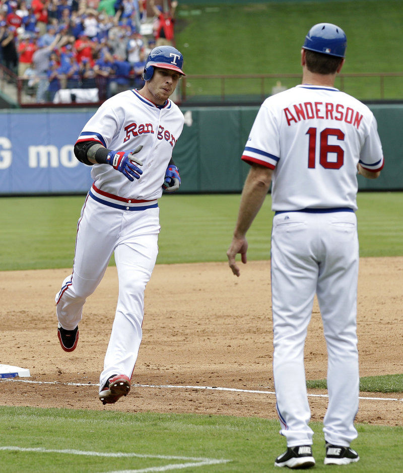 Josh Hamilton greets third-base coach Dave Anderson after Hamilton hit his ninth home run of the week during the Angels’ 4-2 win over the Rangers on Saturday.