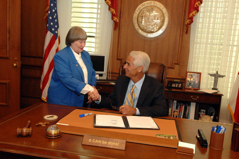 NRA lobbyist Marion Hammer shakes hands in 2008 with Florida Republican Gov. Charlie Crist after passage of a law that lets workers store firearms in their cars while at work.