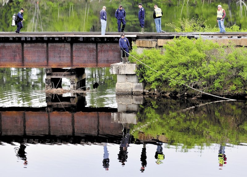 Maine State Police divers search Martin Stream near the Kennebec River off Route 201 in Hinckley on Sunday for the body of a woman driver whose vehicle left the road and launched into the stream late Saturday evening in Fairfield.