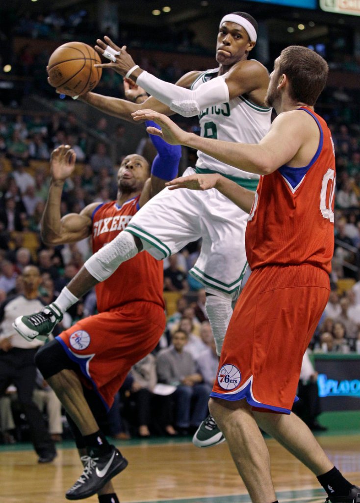Rajon Rondo passes the ball under pressure from Philadelphia’s Andre Iguodala as the 76ers took an 82-81 win Monday night to even their playoff series at 1-1.