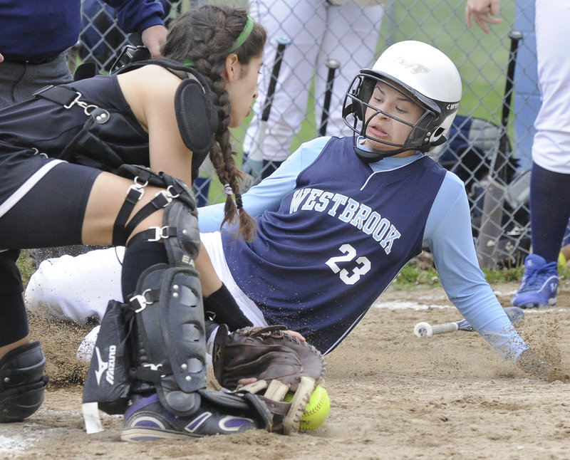 Nicole Nutter of Westbrook slides safely into the plate Tuesday as Marshwood catcher Gianna Riccardi fields the ball during Wesbrook’s 7-6 victory at home.