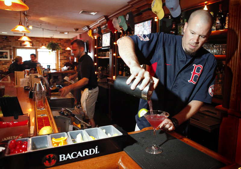 Bartender Nathan Dumas whips up a blueberry martini at Alisson’s.