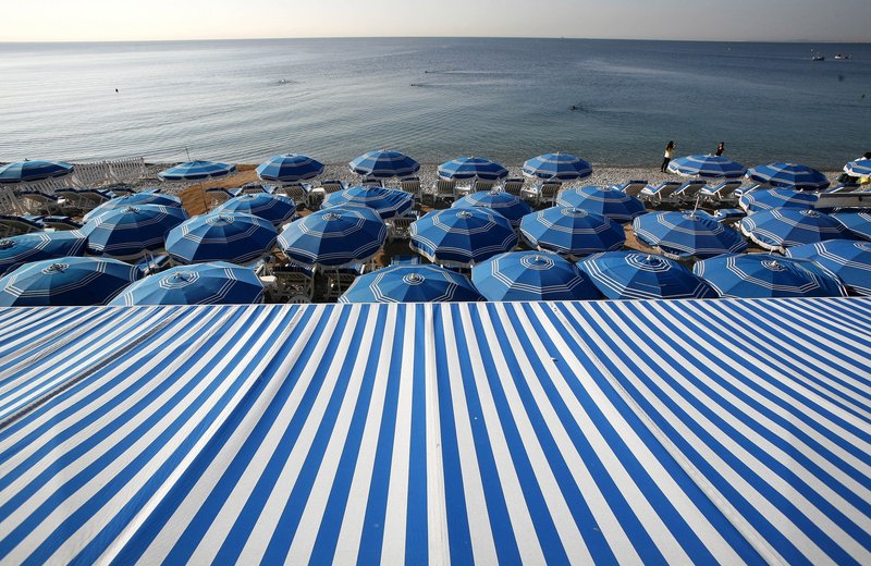 A sea of beach umbrellas provides shade from the sun along the beach in Nice, France.