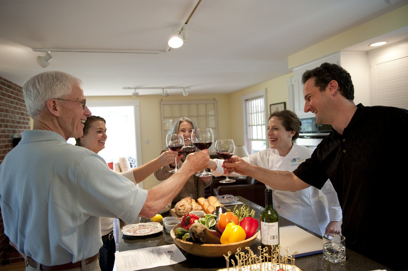 Michelle Goldman toasts students during a recent Mediterranean cooking class held in a Portland home. Goldman hosts more classes this week in Lincolnville and at SMCC.