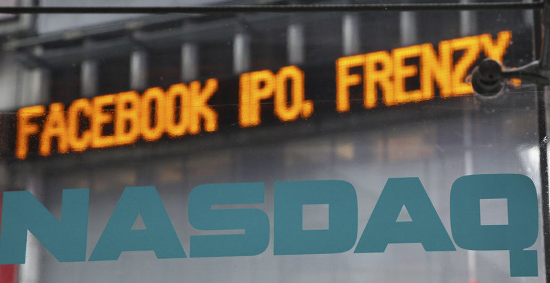 News about the Facebook IPO passes on a billboard Tuesday outside of NASDAQ in Times Square, New York. With little hope of buying shares at the initial offering price, small investors face a “euphoric” first-day price.