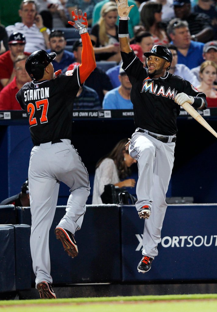 Giancarlo Stanton of the Marlins celebrates with Jose Reyes after hitting a two-run homer in the seventh Wednesday night. Miami won at Atlanta, 8-4.