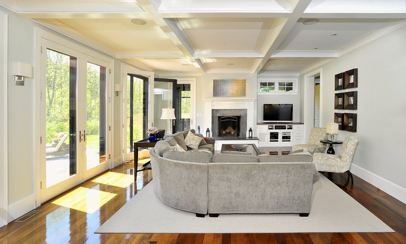 The living room reflects the contemporary style of the home’s interior. French doors lead out to the backyard patio.