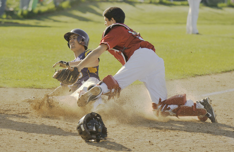 South Portland catcher Adam Helmke tags out Louie DiStasio of Cheverus in the sixth inning Thursday. The Stags had two runners thrown out at the plate in the inning but had built enough of a lead to defeat the Red Riots, 9-4.