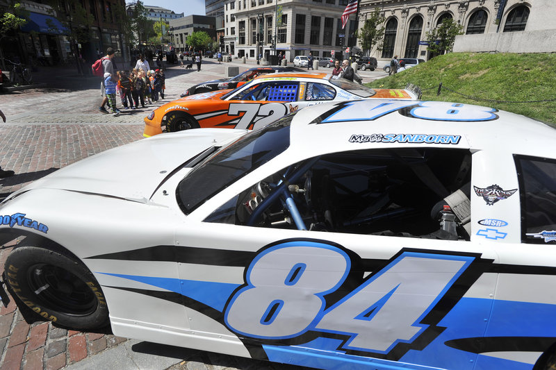 Three race cars were part of the daily rush Friday at Monument Square. Oxford Plains Speedway is opening its season with the Tour event Sunday.