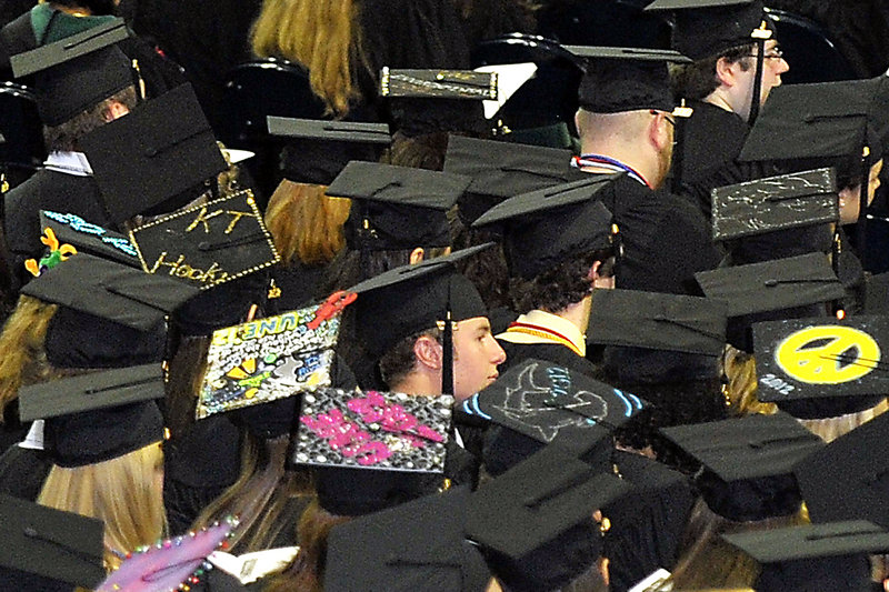 Decorated caps stand out among the graduating students at the University of New England commencement exercises Saturday at the Cumberland County Civic Center.
