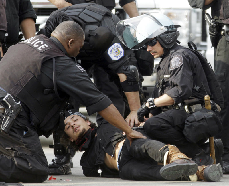 A protester is detained at a march and rally during the NATO summit in Chicago on Sunday. A group of demonstrators clashed with police outside the convention center.