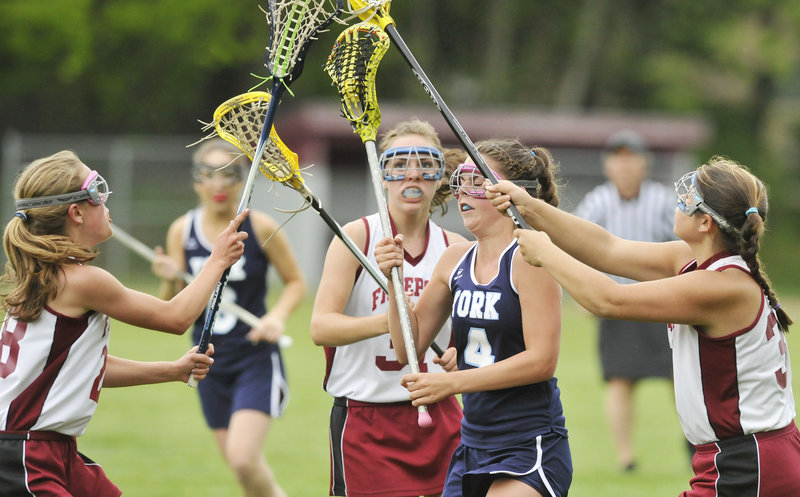 Taylor Simpson of York looks for a shot Tuesday after carrying the lacrosse ball into a crowd of Freeport defenders. Freeport tied the game late in regulation, then scored two goals in overtime and came away with a 10-9 victory.